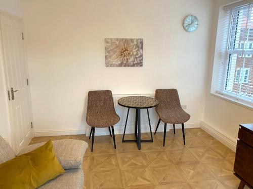 a living room with two chairs and a table at Spacious 1 bedroom flat in London in London