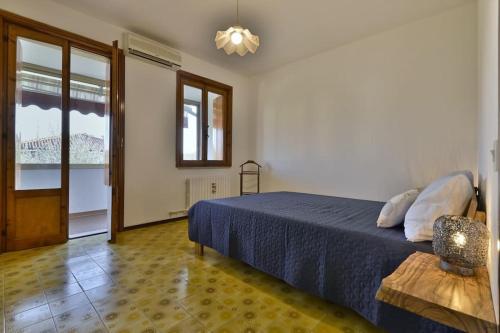 a bedroom with a blue bed and a window at Appartamento Nonna Agnese - Theater Home in Toscolano Maderno