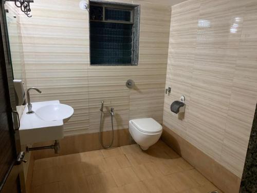 ein Bad mit einem WC und einem Waschbecken in der Unterkunft Ruturaj Inn Alibag in Alibag