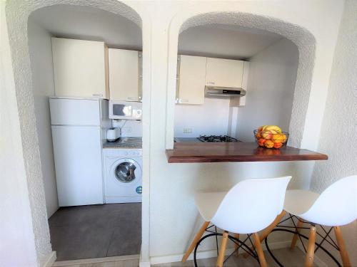 uma cozinha com um frigorífico branco, uma mesa e cadeiras em Apartamentos Strand Jávea em Xàbia