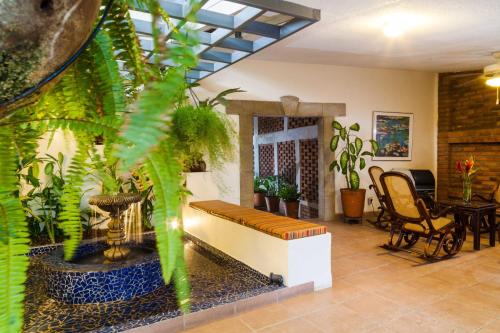 a living room with a bench and plants at Hotel El Almendro in Managua