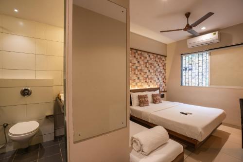 1 dormitorio con cama, aseo y ventana en Zostel Mumbai en Bombay