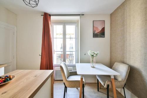 une cuisine avec une table et des chaises blanches ainsi qu'une fenêtre dans l'établissement 31.Studio 2Pers#Sèvres-Lecourbe#Necker, à Paris