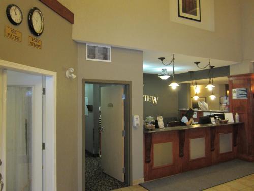 a lobby with a woman at a counter in a restaurant at Lakeview Inns & Suites - Fort Nelson in Fort Nelson