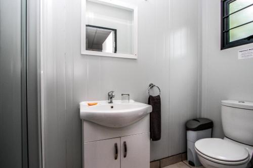 a bathroom with a sink and a toilet at SleepOver Lanseria in Lanseria