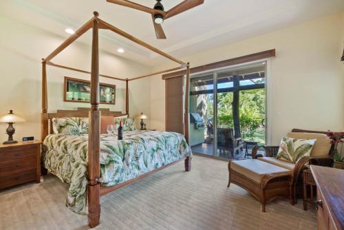 a bedroom with a canopy bed and a chair at Big Island Fairways at Mauna Lani 1705 townhouse in Waikoloa