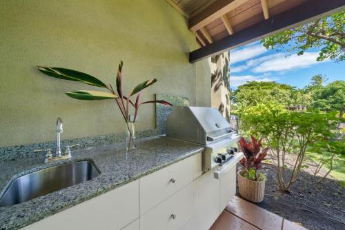 a kitchen with a sink and a counter with a window at Big Island Fairways at Mauna Lani 1705 townhouse in Waikoloa