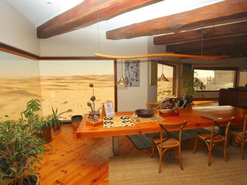 a dining room with a wooden table and chairs at Desert Breeze Lodge in Swakopmund