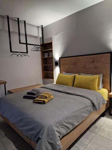 um quarto com uma cama grande e almofadas amarelas em Vv Cosy Host 1 em Lárissa