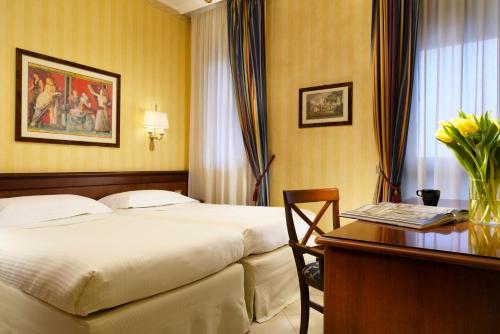 a hotel room with a bed and a desk at UNA Hotels Hotel & Residence Contessa Jolanda Milano in Milan