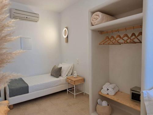 a small bedroom with a bed and a shelf at Amerisa Suites & Villa in Fira