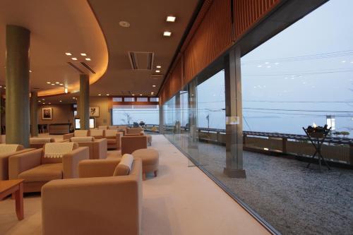 a lobby with couches and chairs and a view of the ocean at Donkairo in Ako