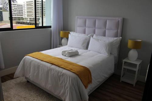 a bedroom with a large white bed and a window at Favour's 2 Bedroom Apartment on 77 in Windhoek