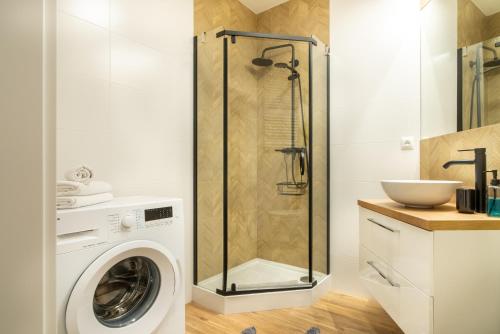 a shower in a bathroom with a washing machine at ApartamentySnu, Struga Tower Gold z parkingiem in Radom