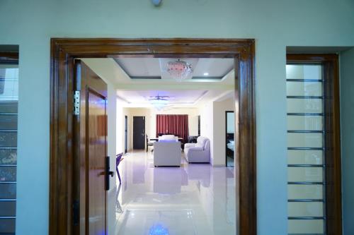 a hallway leading to a living room with white furniture at Ramya Grand in Visakhapatnam