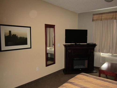 a hotel room with a bed and a television at Lakeview Inns & Suites - Fort Nelson in Fort Nelson