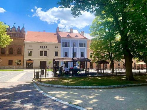 um edifício com uma cerca e uma árvore em frente em historical Zaffir house - market square em Levoča