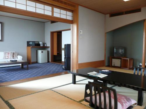 a living room with a table and a refrigerator at Donkairo in Ako
