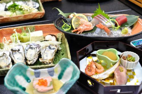 a table topped with trays of seafood and vegetables at Donkairo in Ako