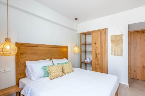 a bedroom with a white bed with pillows on it at Absolute Kiotari Resort in Kiotari