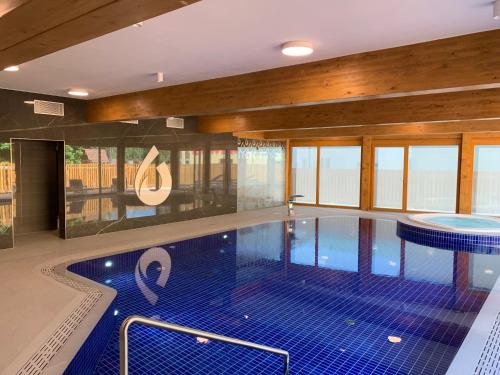 a large swimming pool with blue tiles in a building at Apartmany Rezidence Klostermann & Javor & Skalka in Železná Ruda
