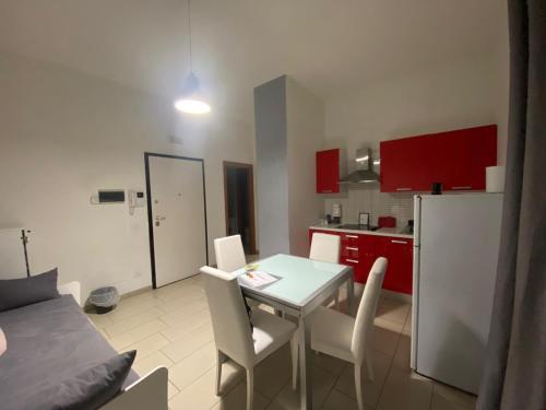 una cucina con tavolo, sedie e armadi rossi di De Gasperi House a Napoli