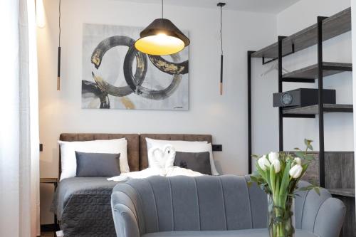 een woonkamer met een bed en een vaas met bloemen bij Apartmani Mozart-centar Virovitica in Virovitica