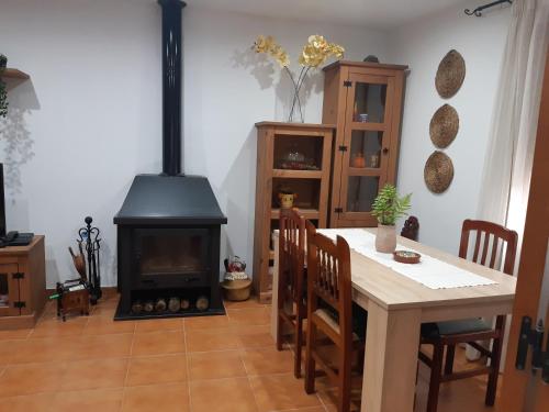 ein Wohnzimmer mit einem Kamin, einem Tisch und einem Herd in der Unterkunft Casa Rural Fray Eloy in Guadalupe