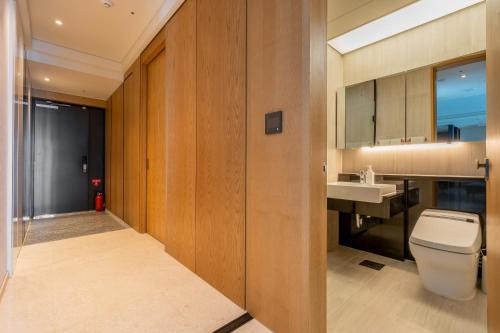 a bathroom with a toilet and a sink at LCT Residence Y collection in Busan