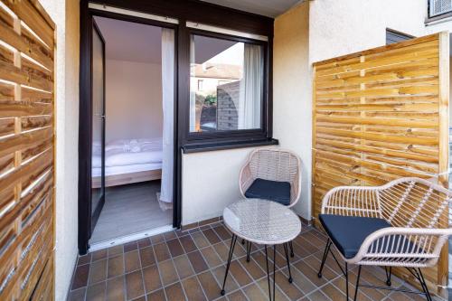 a balcony with two chairs and a table and a window at Nettes Apartment mit Terrasse in Würzburg
