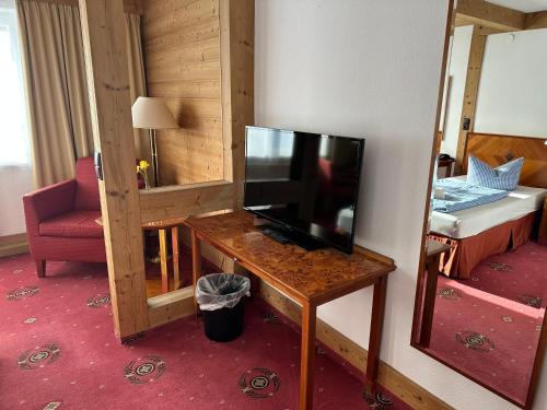 a room with a television on a table with a bedroom at Hotel Söllner in Tettau