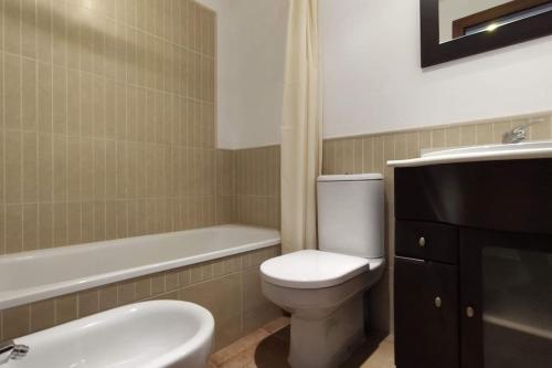 Apartamento Los Pelícanos في إيسلا كانيلا: حمام مع مرحاض ومغسلة وحوض استحمام