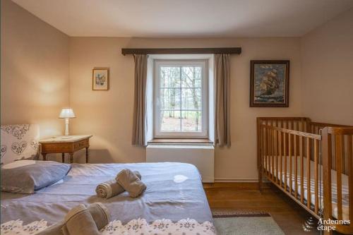 ein Schlafzimmer mit einem Bett, einem Fenster und einem Kinderbett in der Unterkunft La Conciergerie in Beauraing