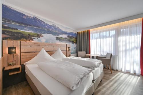Hotel Ruchti - Zeit für mich في فوسن: غرفة نوم بسرير كبير عليها لوحة على الحائط