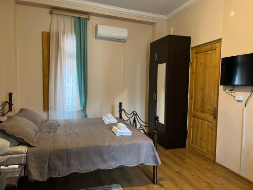 Dormitorio pequeño con cama y nevera en Cozy Apartment, en Tiflis