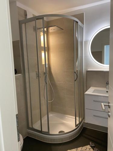 W łazience znajduje się prysznic ze szklanymi drzwiami. w obiekcie Ostsee Ferienwohnung in Sierksdorf - Hansa Park w mieście Sierksdorf