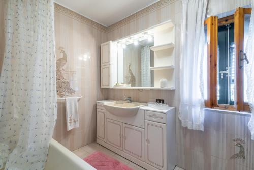 uma casa de banho com um lavatório, uma banheira e um espelho. em Le Balze nel cuore della Toscana em Castelfranco di Sopra