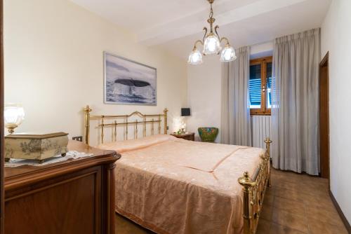 um quarto com uma cama com uma cómoda em madeira e uma janela em Le Balze nel cuore della Toscana em Castelfranco di Sopra