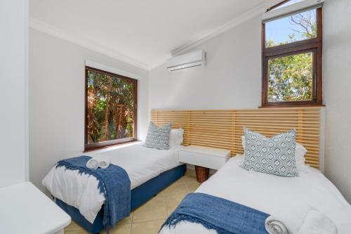 two beds in a room with two windows at San Lameer Villa 3207 - 3 Bedroom Superior - 6 pax - San Lameer Rental Agency in Southbroom