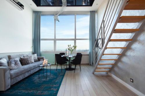 a living room with a couch and a table with chairs at Panorama- the View of Gdańsk by Elite Apartments in Gdańsk