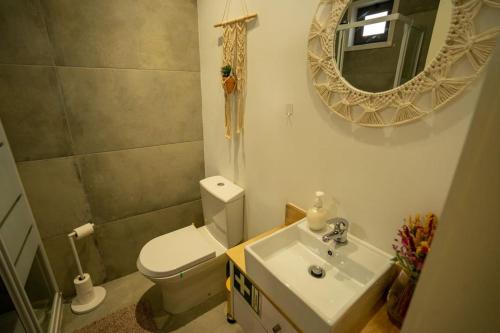a bathroom with a toilet and a sink and a mirror at Ilha D'ouro House S. Vitor II in Porto