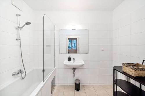 ein weißes Bad mit einem Waschbecken und einer Dusche in der Unterkunft Arbio I Design Apartments in Favoriten Vienna in Wien