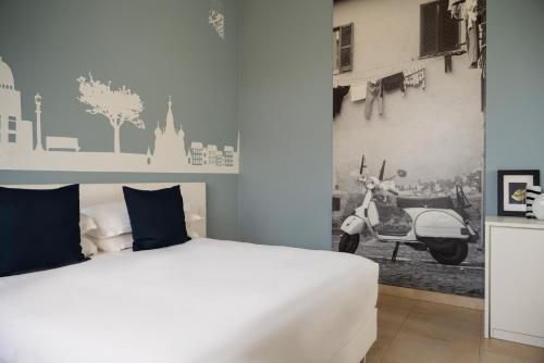 ein Schlafzimmer mit einem weißen Bett und einem Roller an der Wand in der Unterkunft Castello D'Argile Hotel in Castello dʼArgile