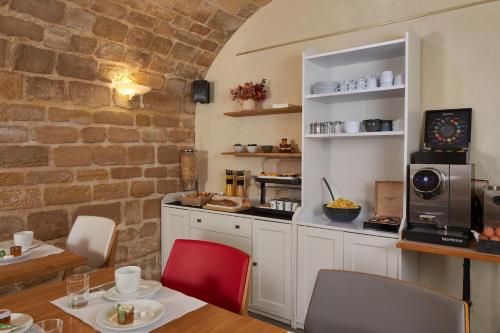 a kitchen with a table and chairs and a counter at Grand Hôtel Malher in Paris
