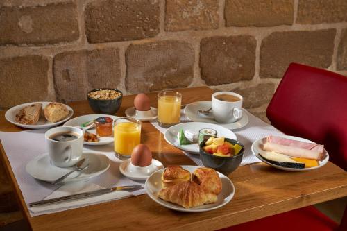 a table with a breakfast of eggs and croissants at Grand Hôtel Malher in Paris