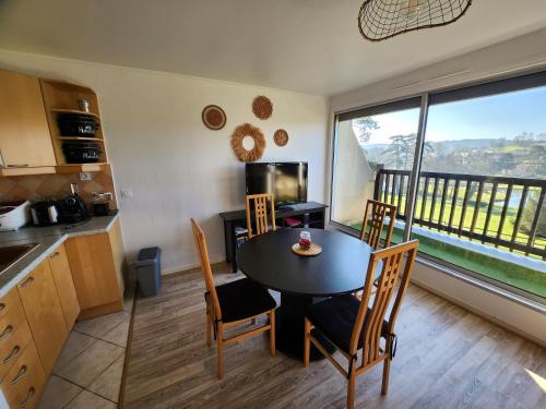 a kitchen and dining room with a table and chairs at Le Green - Appt Houlgate vue sur le golf in Houlgate