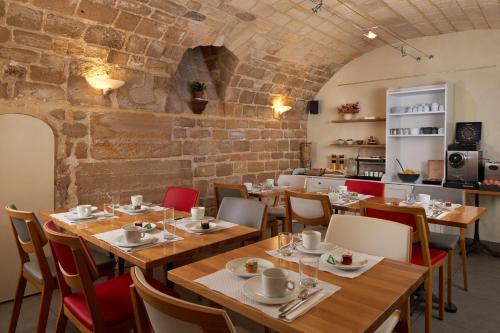 a restaurant with wooden tables and chairs and a brick wall at Grand Hôtel Malher in Paris