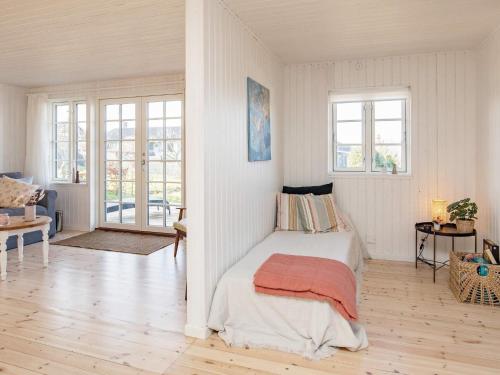 a white bedroom with a bed and two windows at Holiday home Kerteminde XII in Kerteminde