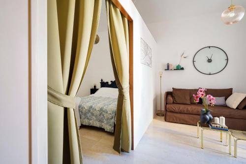 a living room with a bed and a curtain at Dimora a Palazzo in Monopoli