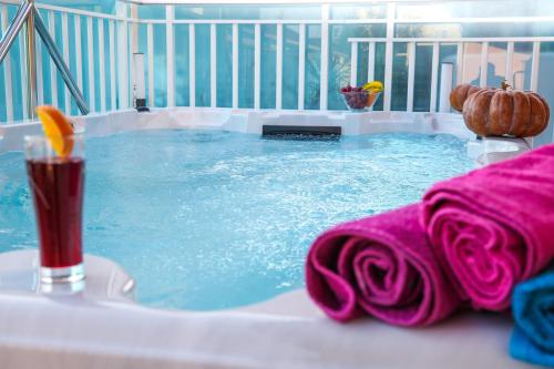 a hot tub with a drink and pink towels at Apartment Rose Pool Comfort in Dubrovnik